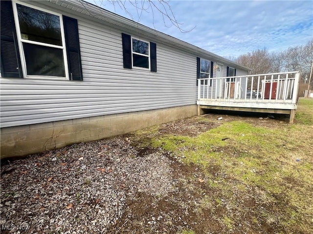 view of side of property with a lawn and a deck