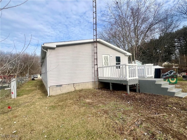 rear view of property with a wooden deck and a yard