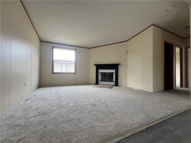 unfurnished living room featuring ornamental molding and carpet