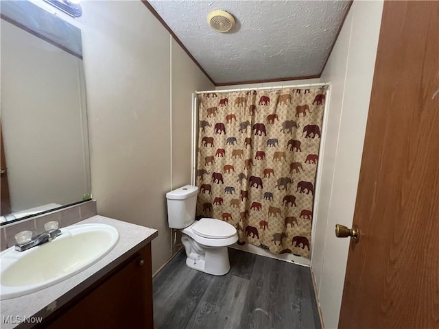 bathroom featuring hardwood / wood-style floors, vanity, ornamental molding, a textured ceiling, and toilet