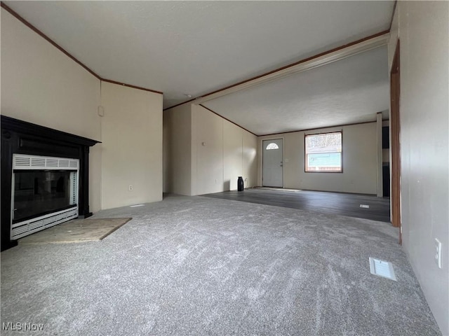 unfurnished living room featuring vaulted ceiling and carpet flooring