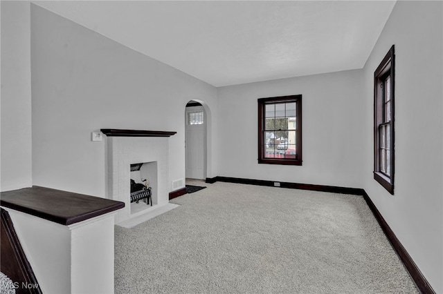 unfurnished living room featuring carpet floors and a fireplace