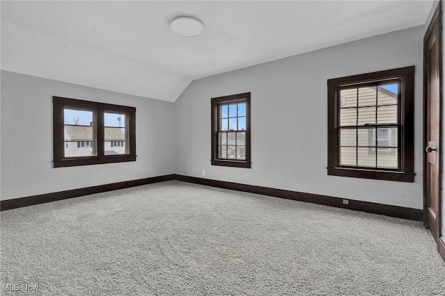 carpeted empty room featuring lofted ceiling