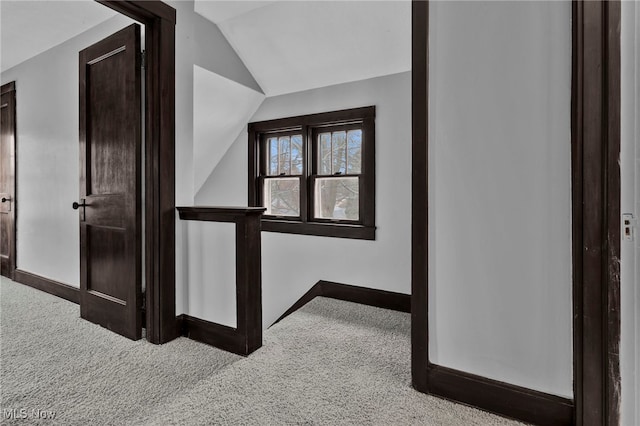 corridor featuring lofted ceiling and carpet floors