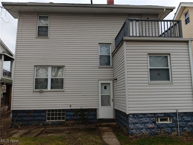 back of house featuring a balcony