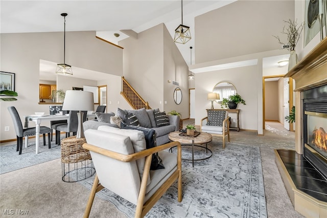 living room with a multi sided fireplace, light carpet, and high vaulted ceiling