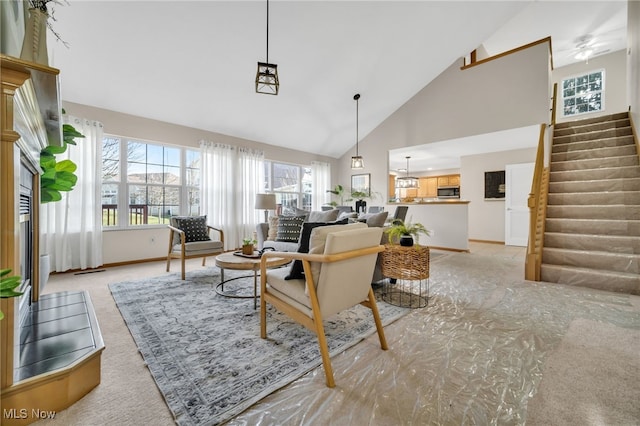 carpeted living room featuring high vaulted ceiling