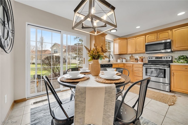 kitchen featuring sink, appliances with stainless steel finishes, light tile patterned flooring, decorative backsplash, and a chandelier