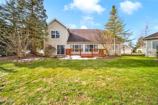 rear view of house featuring a deck and a lawn