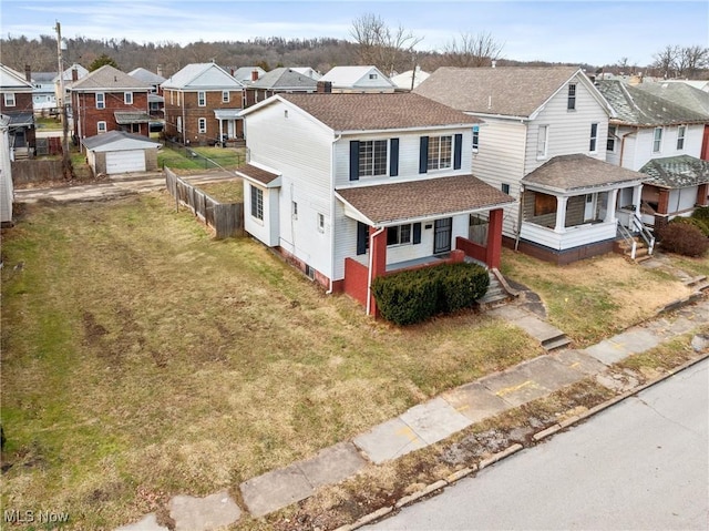 view of front of home with a garage, an outdoor structure, a porch, and a front yard