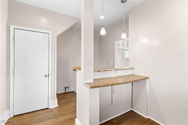 kitchen with hanging light fixtures, hardwood / wood-style flooring, and kitchen peninsula