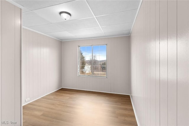 empty room featuring crown molding and light wood-type flooring