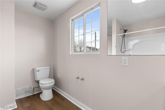 bathroom featuring wood-type flooring, walk in shower, and toilet