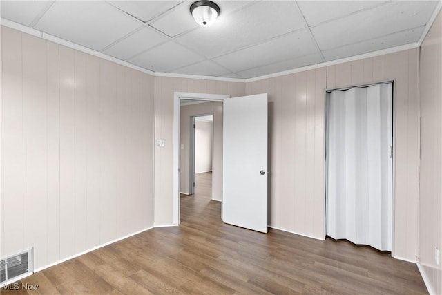 spare room featuring a paneled ceiling, ornamental molding, and hardwood / wood-style floors