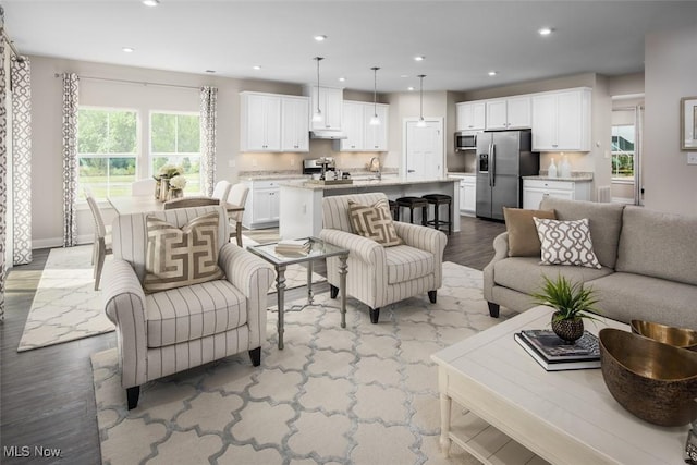 living room featuring plenty of natural light, sink, and light hardwood / wood-style floors