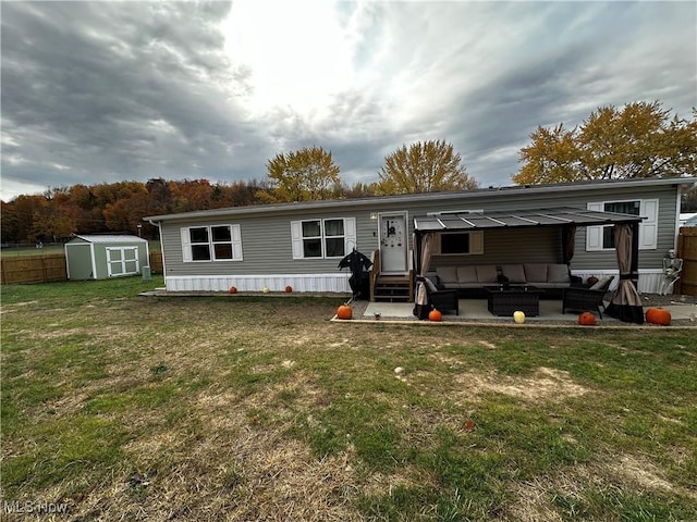 back of property with an outdoor living space, a yard, a patio, and a shed