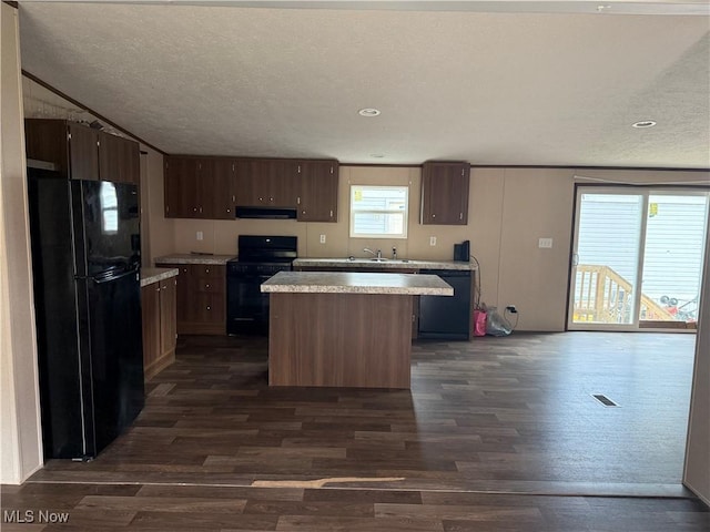 14000 Lincoln St SE, Minerva, OH 44657 - kitchen featuring black appliances, extractor fan, light countertops, a center island, and dark wood-style flooring