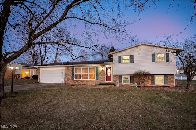 split level home featuring a garage and a yard