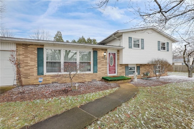 tri-level home featuring a garage and a front lawn