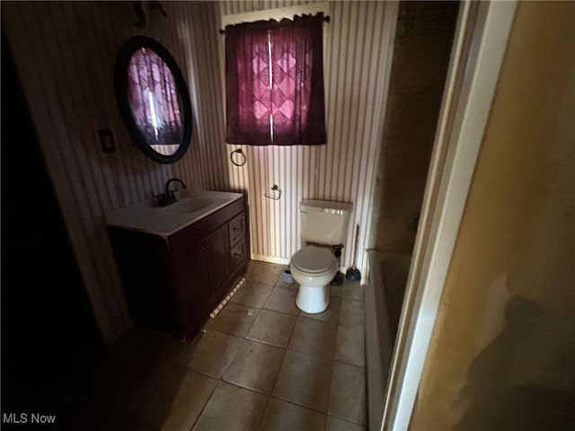 bathroom with tile patterned flooring, vanity, and toilet