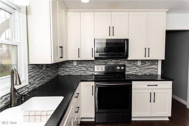 kitchen with sink, dark wood-type flooring, white cabinetry, electric range, and tasteful backsplash