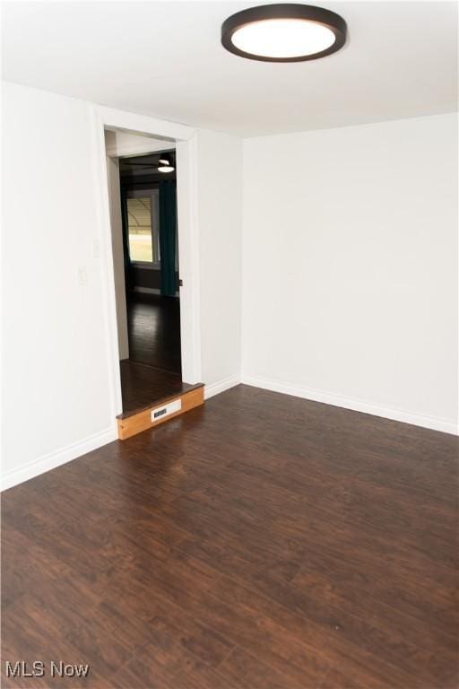 unfurnished room with dark wood-type flooring