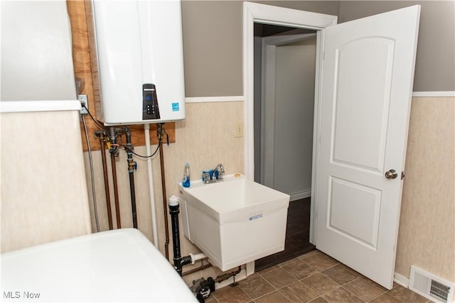 utility room with water heater and sink