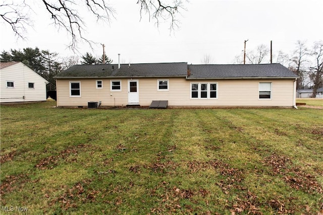 rear view of house featuring central AC and a yard