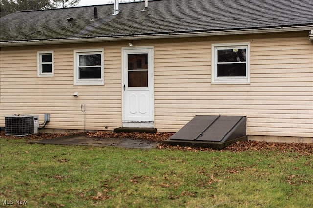 rear view of property with a yard and central AC