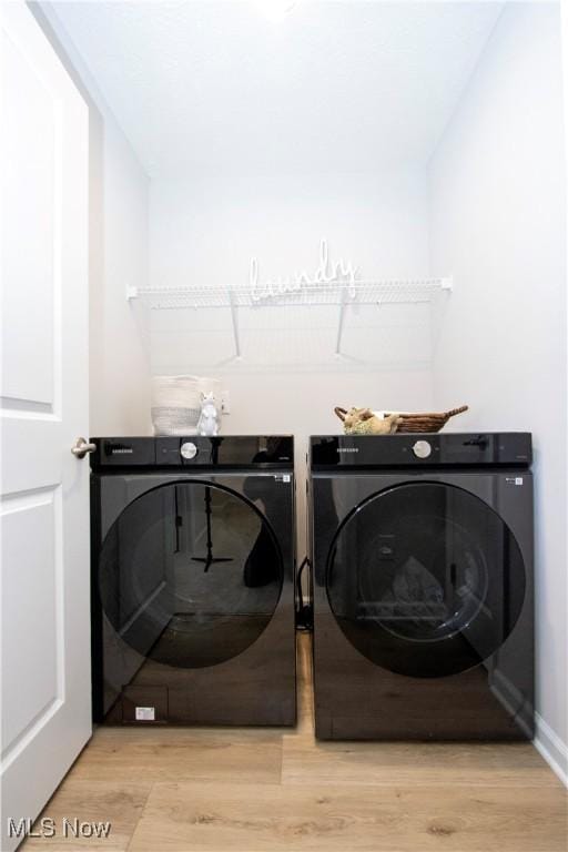 washroom with washer and dryer and light hardwood / wood-style flooring