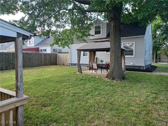 rear view of house featuring a gazebo, a patio area, and a lawn