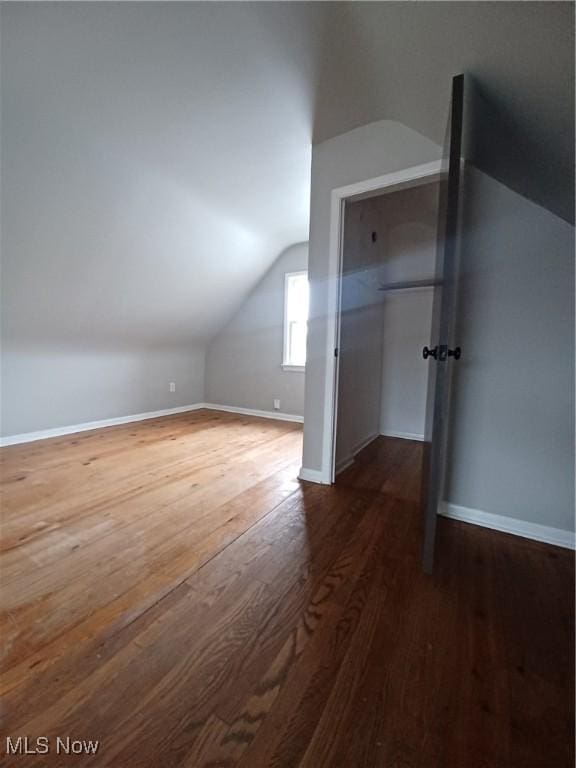 additional living space featuring lofted ceiling and dark hardwood / wood-style floors