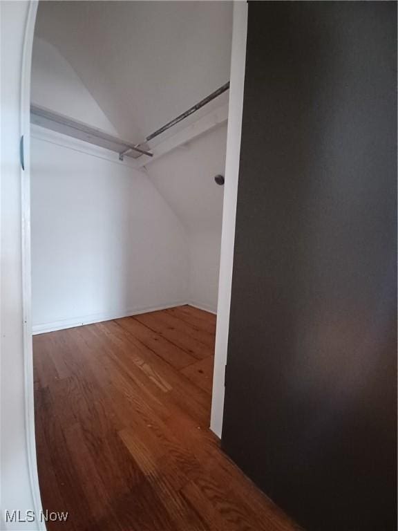 spacious closet with hardwood / wood-style flooring and vaulted ceiling