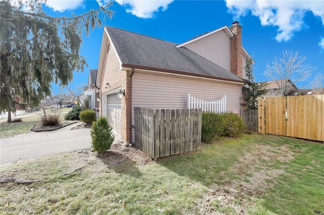 view of side of home with a yard and a garage