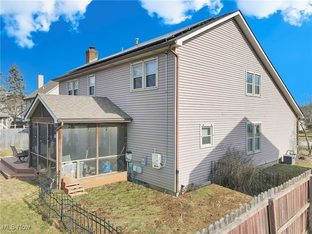 rear view of house featuring a sunroom