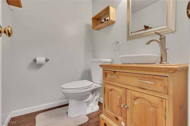 bathroom with vanity, toilet, and hardwood / wood-style floors