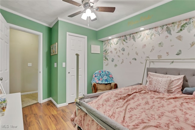 bedroom featuring a closet, ornamental molding, light hardwood / wood-style floors, and ceiling fan