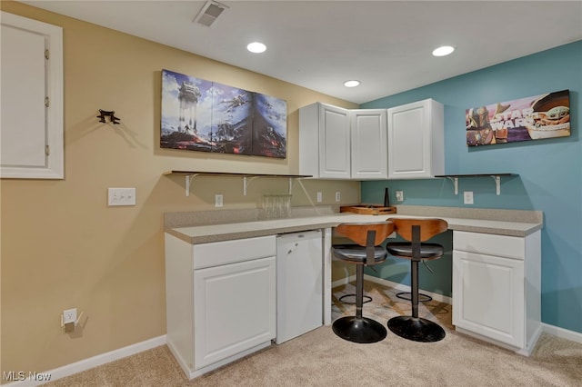 kitchen with white cabinetry and light carpet