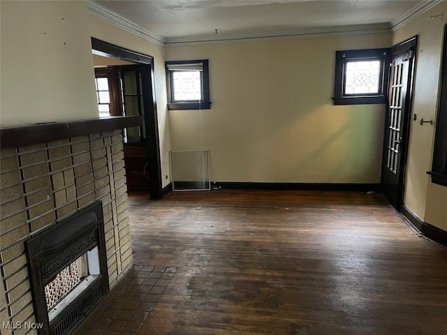 unfurnished living room featuring dark wood-type flooring, ornamental molding, and heating unit