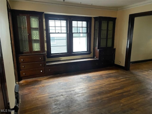 spare room featuring ornamental molding and dark hardwood / wood-style floors