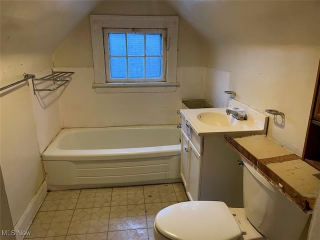 bathroom featuring lofted ceiling, vanity, toilet, and a washtub