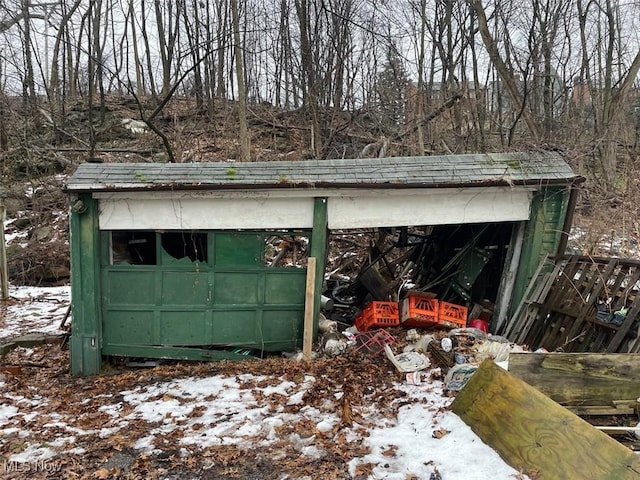 snow covered structure with a garage