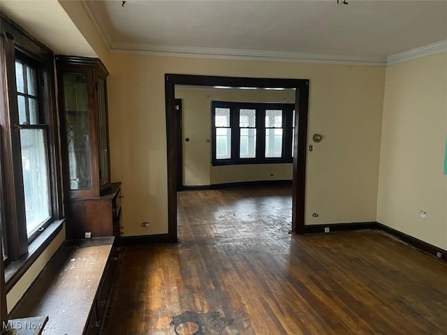 empty room featuring ornamental molding and dark hardwood / wood-style floors