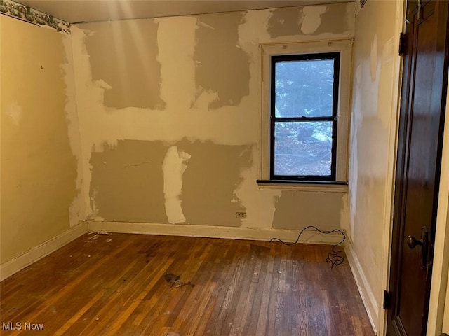 unfurnished room featuring dark wood-type flooring