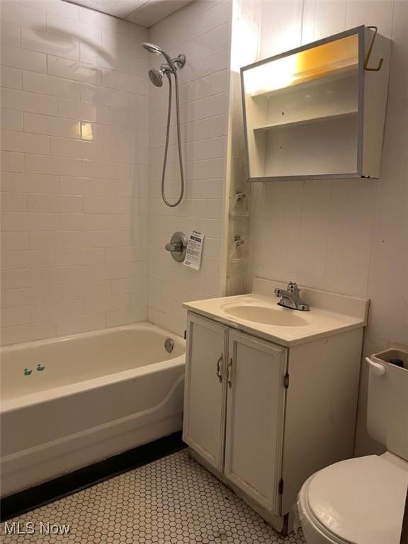 full bathroom with tiled shower / bath, vanity, and toilet