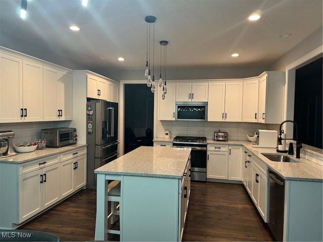 kitchen with pendant lighting, stainless steel appliances, and white cabinets