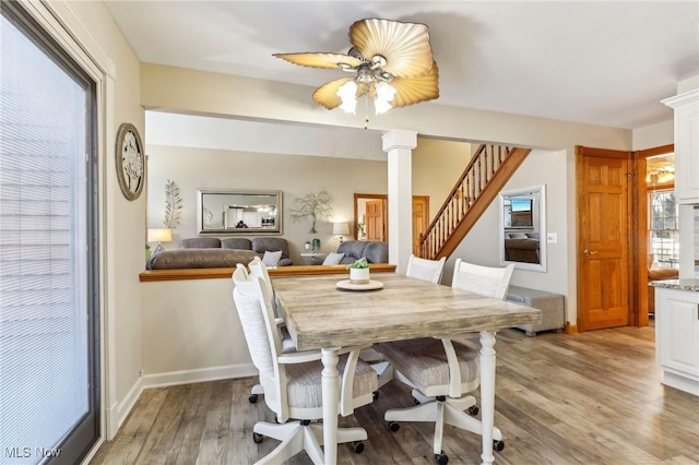 dining space featuring light hardwood / wood-style floors, decorative columns, and ceiling fan