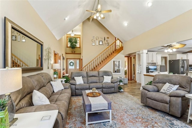 living room featuring ornate columns, wood-type flooring, high vaulted ceiling, and ceiling fan