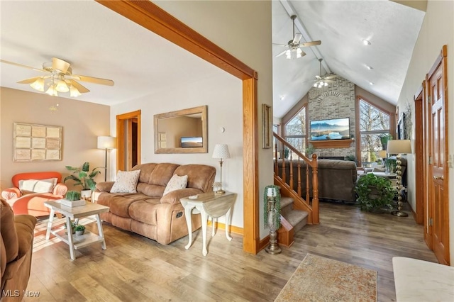 living room with vaulted ceiling, ceiling fan, a fireplace, and hardwood / wood-style floors