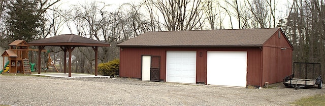 view of outdoor structure with a garage and a playground